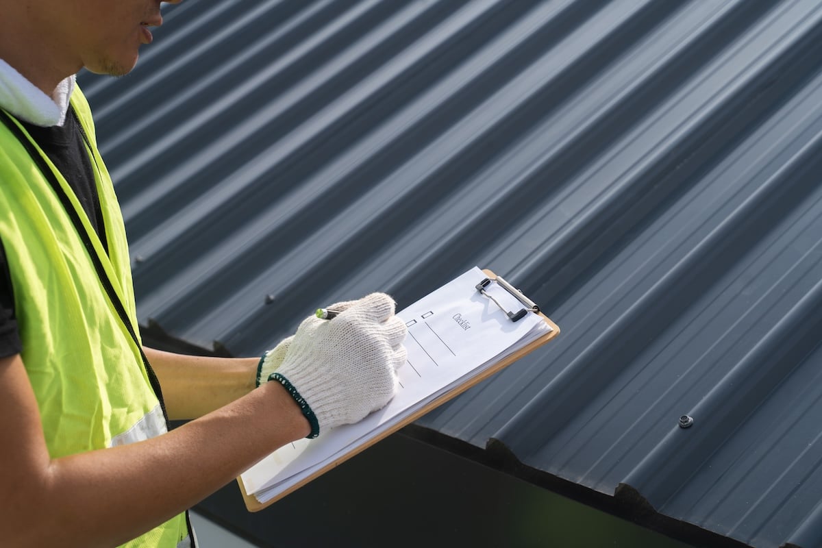 inspecting roof with clipboard