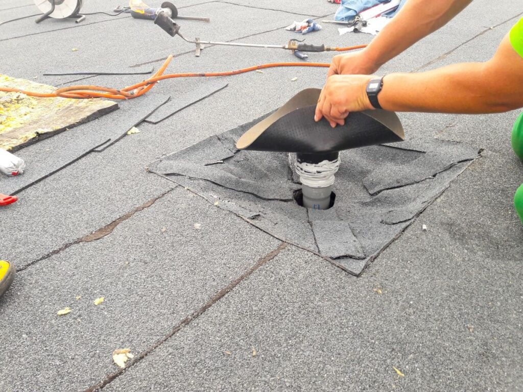 commercial roof leak detection worker repairing flashing