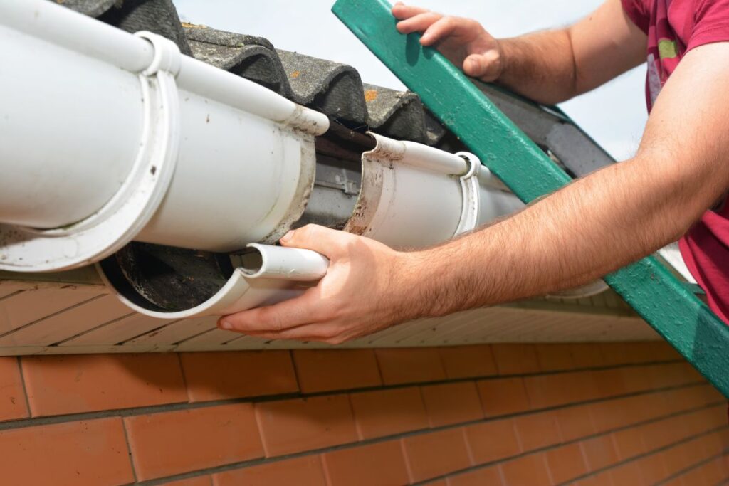 rain gutter repair hands fixing metallic water system