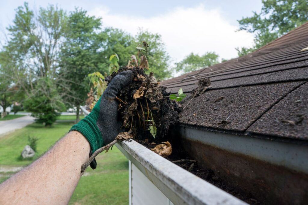 how long do gutters last worker using glove to remove leaves