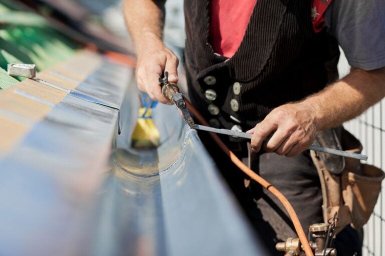 how long do gutters last worker using tools to fix metallic gutter