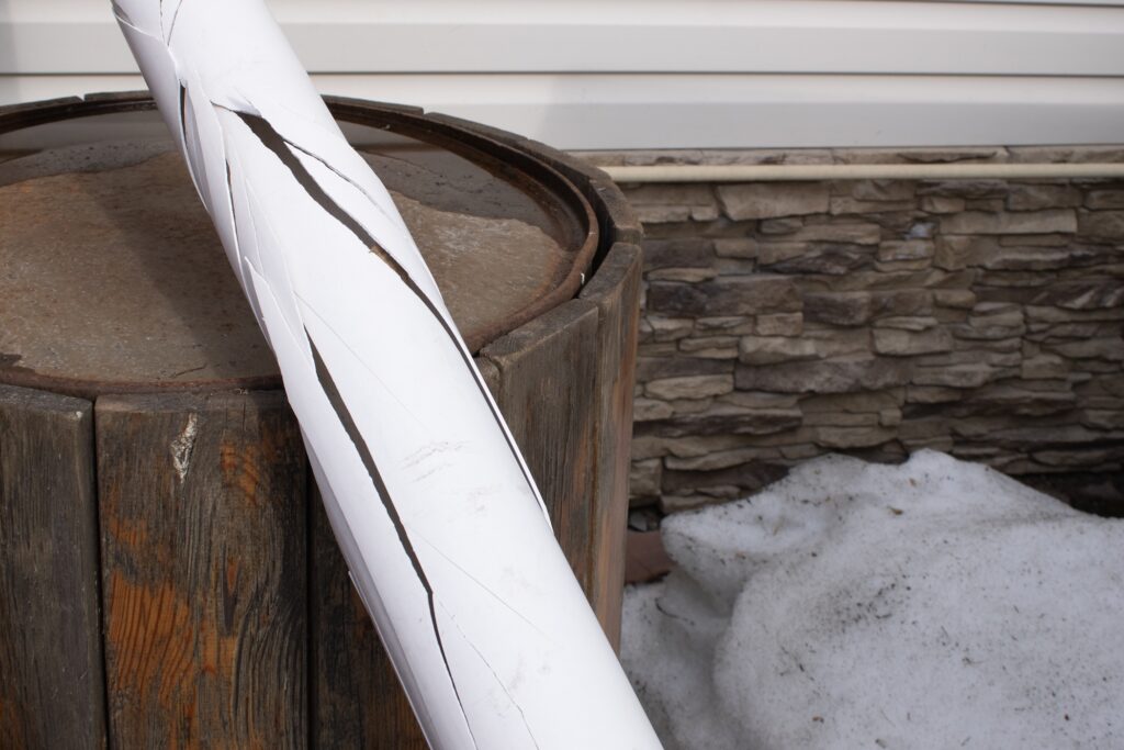 Weathered Wooden Barrel with Cracked Paper Rolled on Top Depicting Timeworn Beauty of Nature Against a Backdrop of Snow and Stone