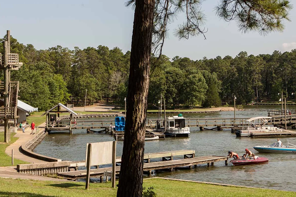 Fishing docks and boats beside the wooded shore at Lake Livingston State Park near Livingston, Texas.